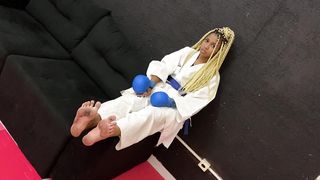 A slave licks the feet of a karate girl after training