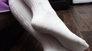 Сексуальная школьница одевает белые гольфы и показывает свои стопы