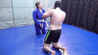 Girl wearing gi wrestling older guy