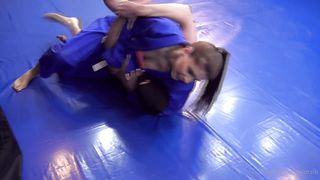 Girl wearing gi wrestling older guy