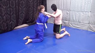 Girl wearing gi wrestling older guy